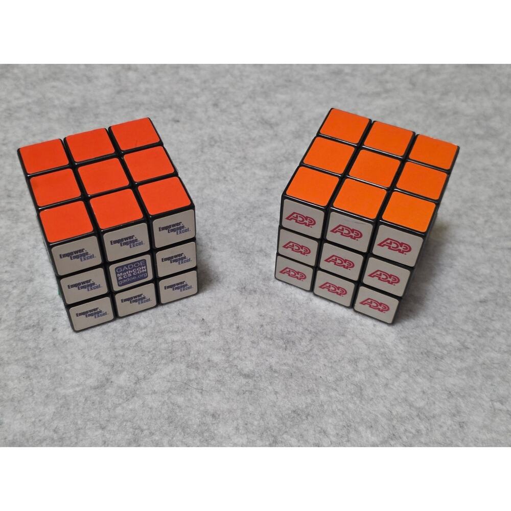 Lot of 2 Promotional 3x3 Rubik's Cube Puzzle Toys Orange ADP and Gadoe